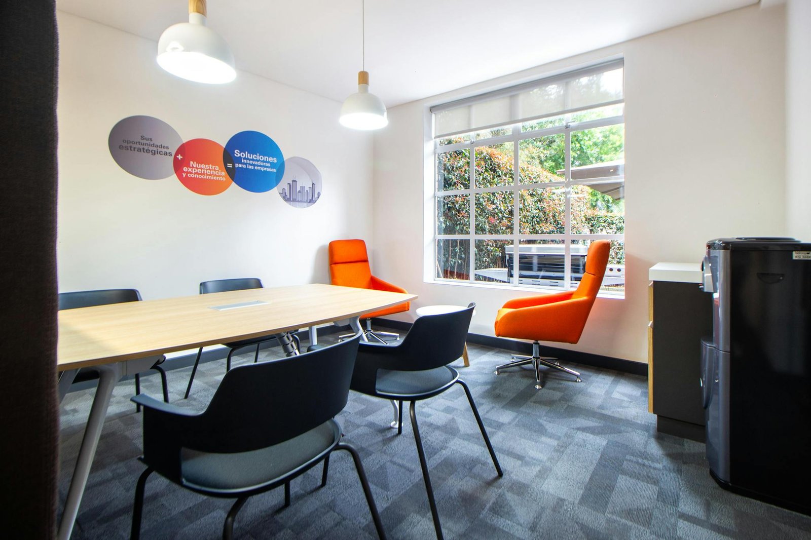 Bright contemporary conference room featuring modern furniture and large window.